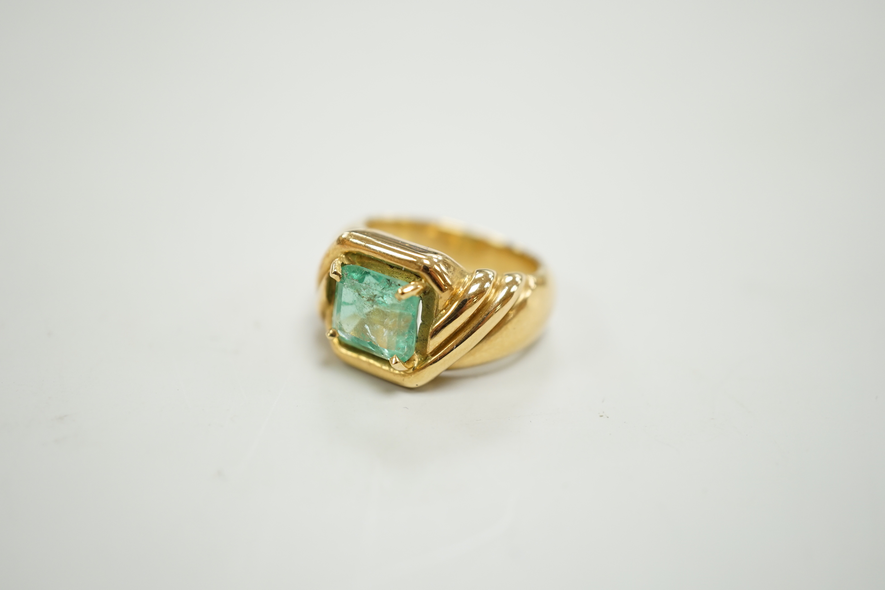 A yellow metal and single stone emerald set dress ring, with fluted shoulders, size I/J, gross weight 10.3 grams.